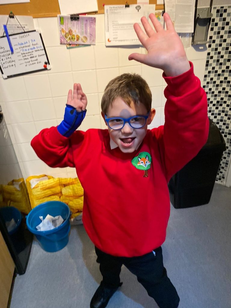 Boy wearing glasses dances in school uniform