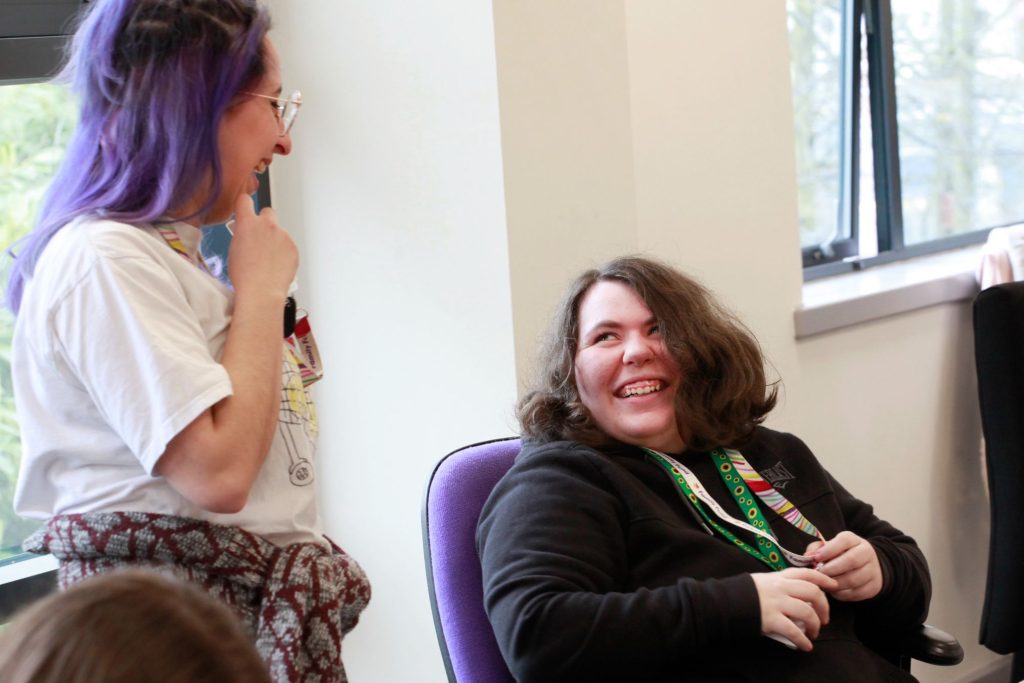 Charlotte and her job coach, laughing together in an office