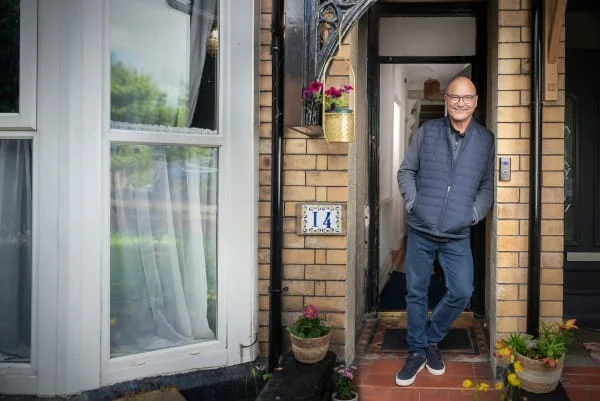 Greg stands in a doorway
