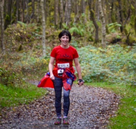 Woman on trail in woods taking part in a race