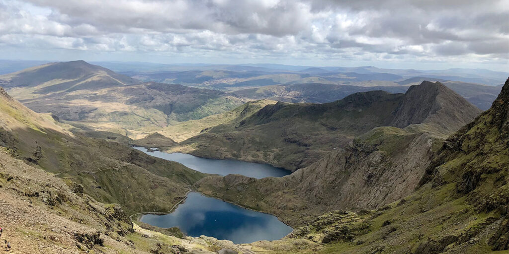 A view from high up of large mountains and lakes in the distance