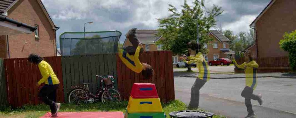 Photo montage of a young boy wearing a yellow tracksuit doing parkour  outside, with jumping blocks