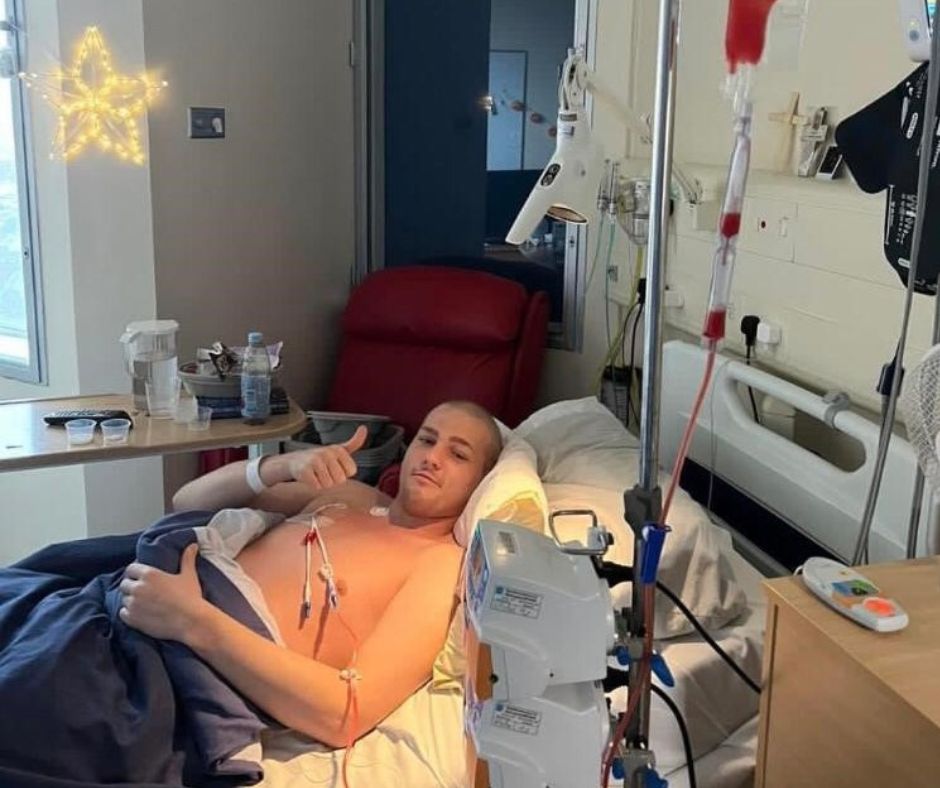 Leroy, aged 19, gives a smile and a thumbs up as he lies in his hospital bed receiving treatment for leukaemia.