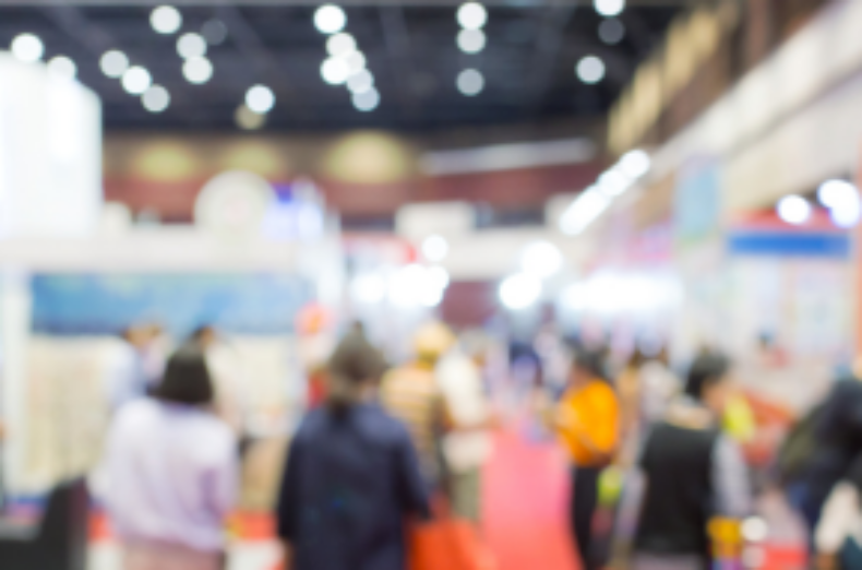 An out of focus photo of a crowded exhibition hall