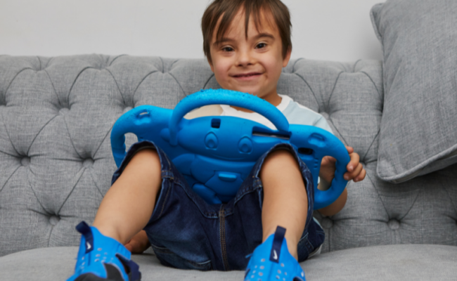A young boy sitting on a sofa with a tablet.