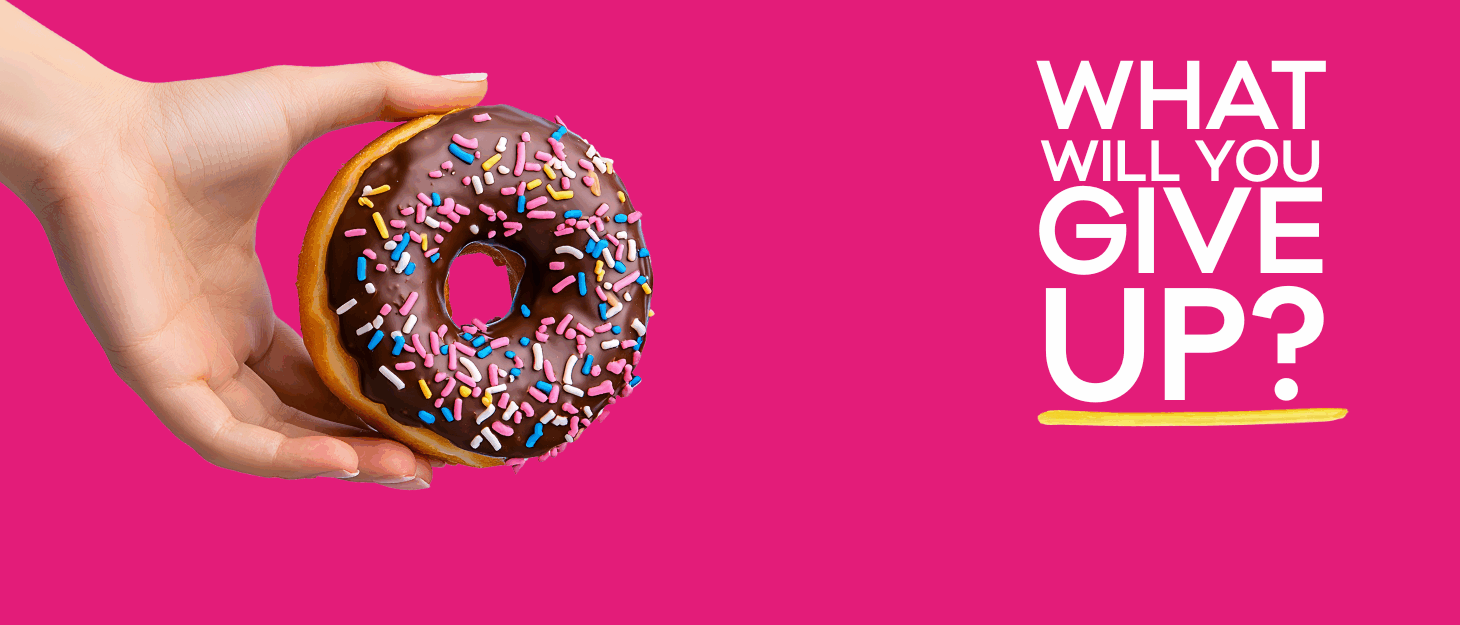 A pink background. On the right, a hand holds a chocolate donut with colourful sprinkles. On the left, white text reads 'WHAT WILL YOU GIVE UP?'