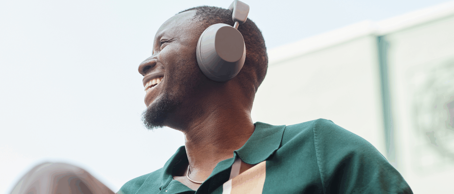 A young man in a wheelchair looking into the distance wearing headphones