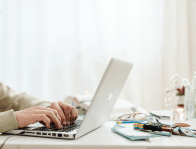A young man wearing headphones typing on a laptop