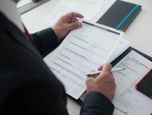 hands holding document with pen in hand