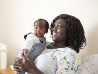 A mum holding a toddler in her arms