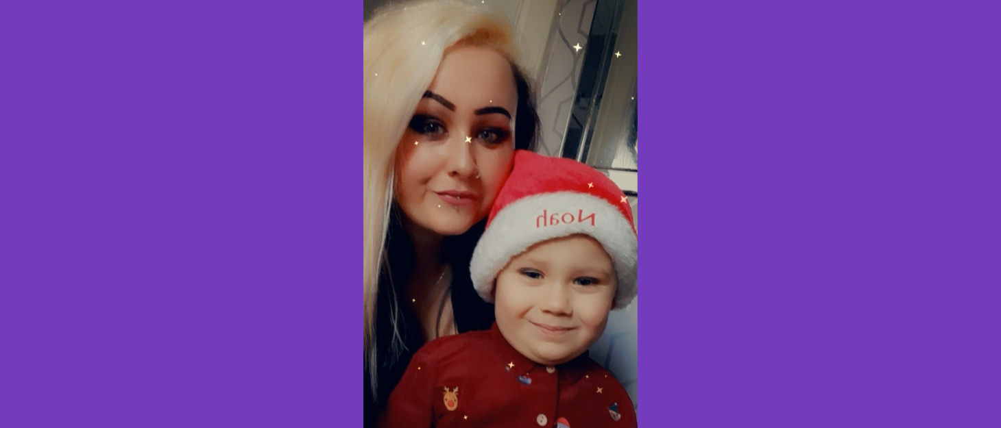 Selfie of Rebecca and Noah. Noah is wearing a santa hat with his name on it.