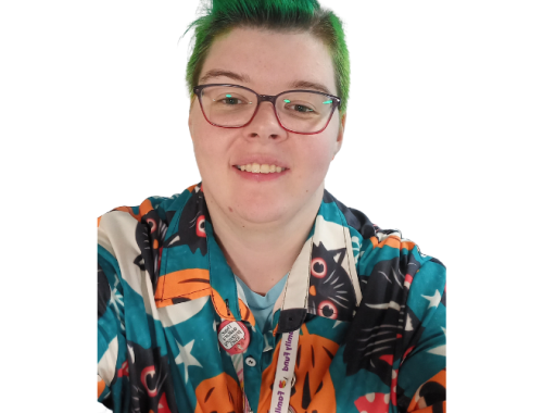 A young woman with short green hair wears glasses and a patterned shirt