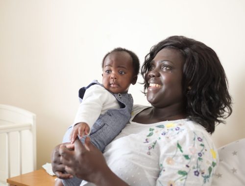 A mum holding a toddler in her arms