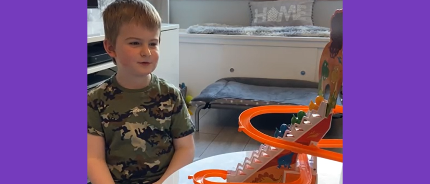 Boy watches a marble run toy on the table