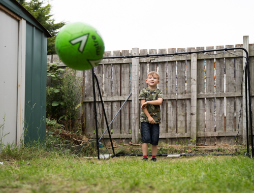 a boy playing football outside