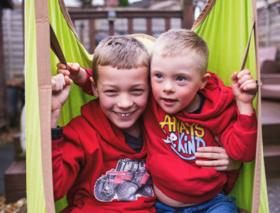 Two young brothers playing outside on garden play equipment