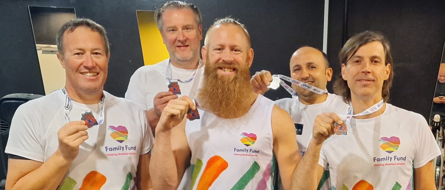 Five men wearing Family Fund t-shirts holding their event medals