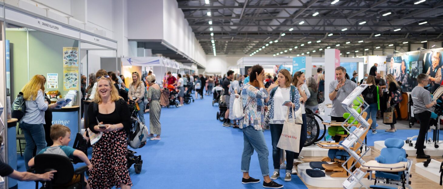 A large exhibition hall with stands and people walking around